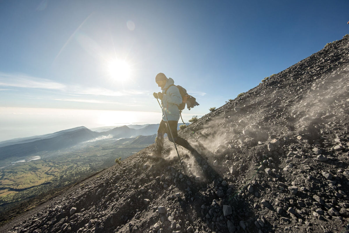Hiker going down steep mountain with hiking poles